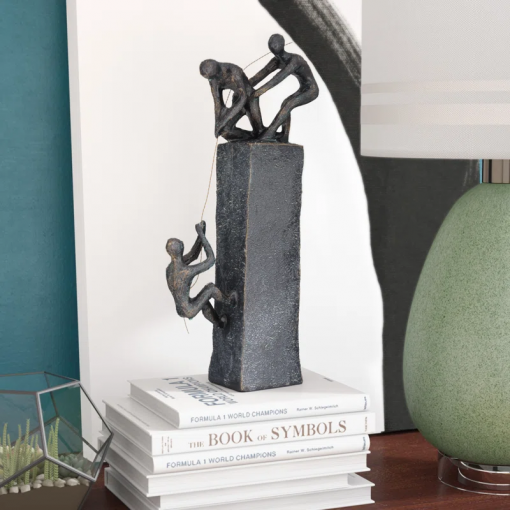 gray polystone people climbing decorative sculpture with bronze detailing, 7" x 3" x 17"