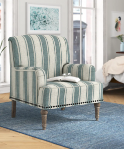 arching armchair with solid wood legs and nailhead trim