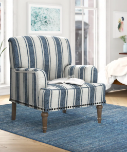 arching armchair with solid wood legs and nailhead trim