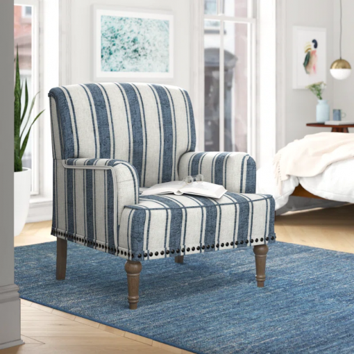 arching armchair with solid wood legs and nailhead trim